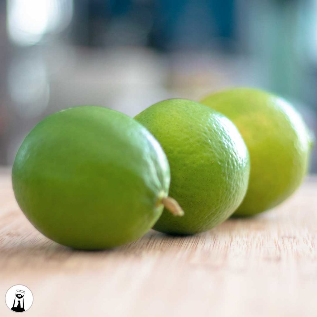 three limes on a cutting board