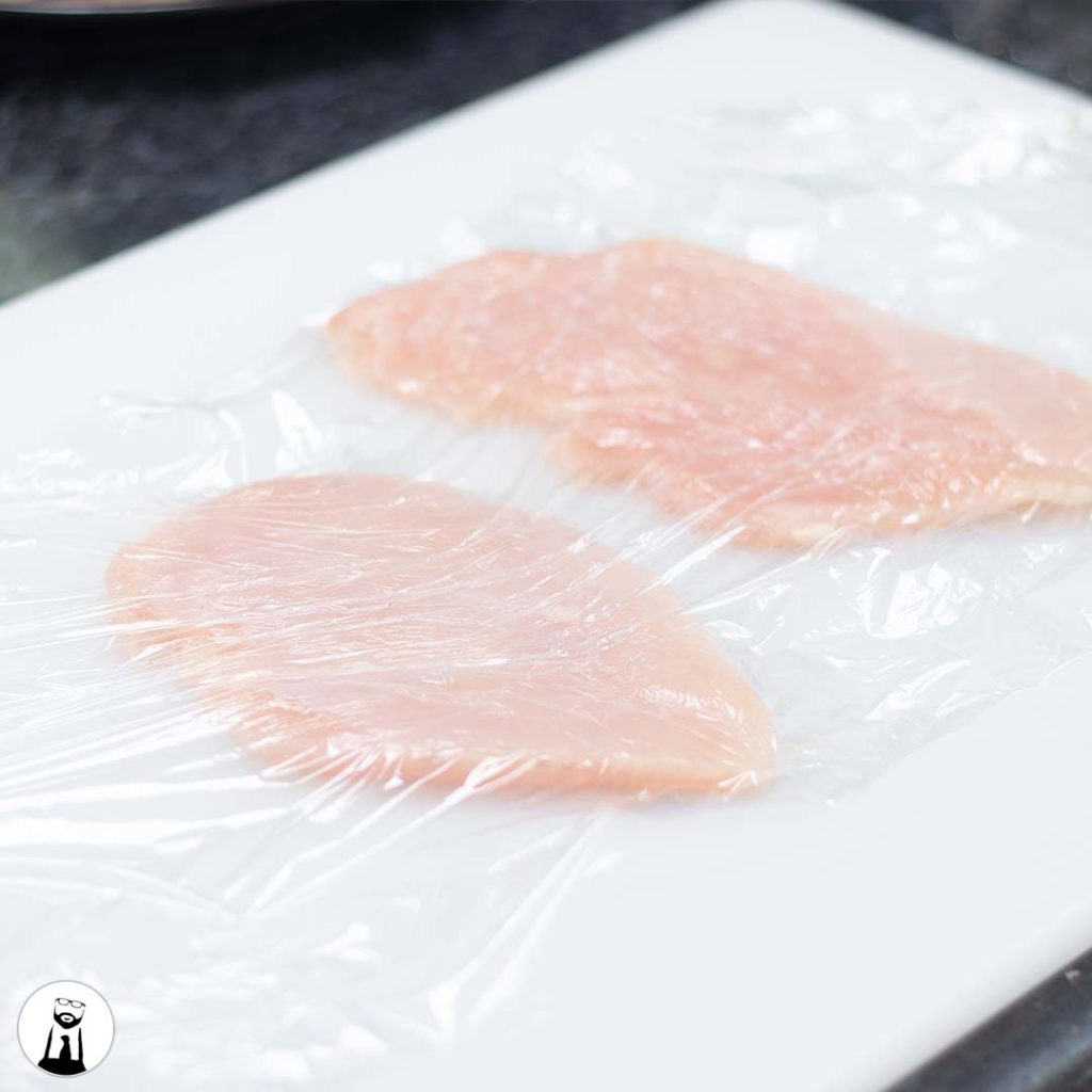 Chicken breast under plastic wrap - Black Tie Kitchen