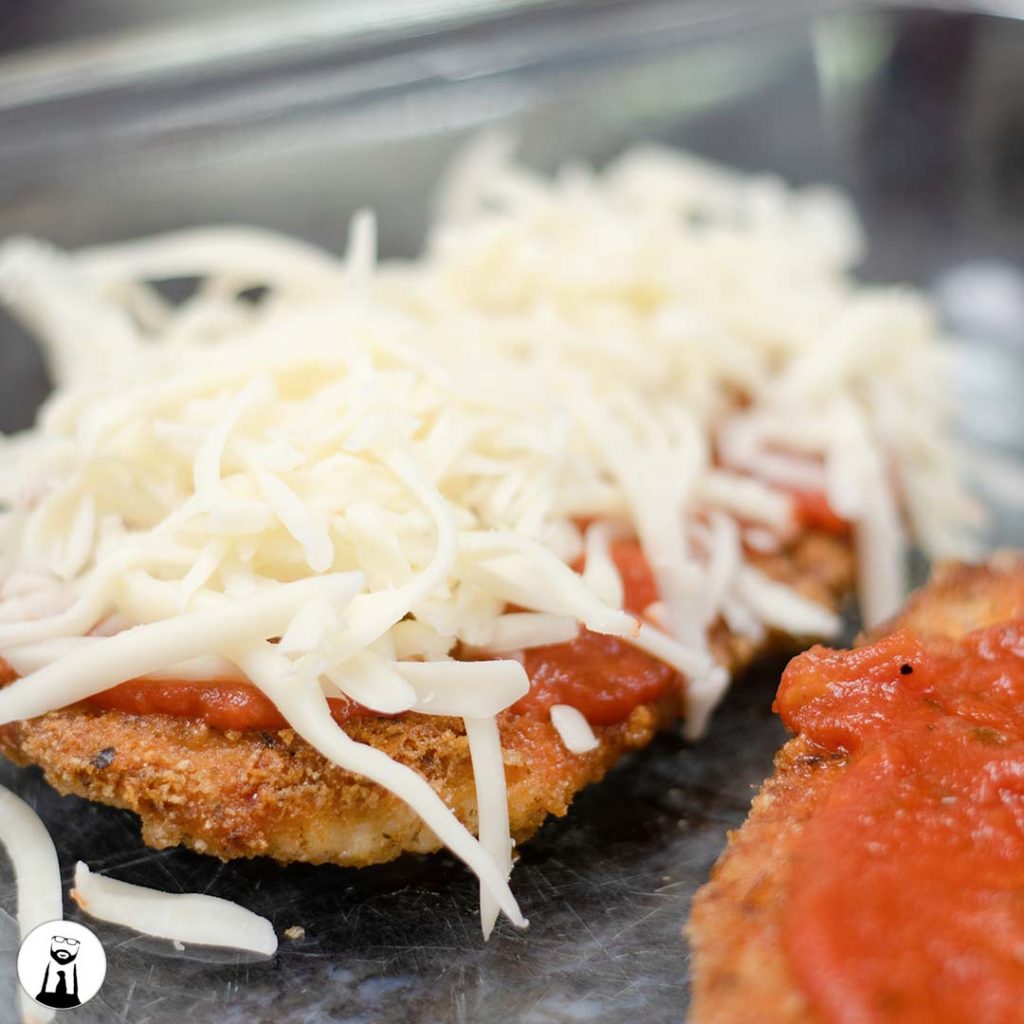 cheese and sauce on breaded chicken - Black Tie Kitchen
