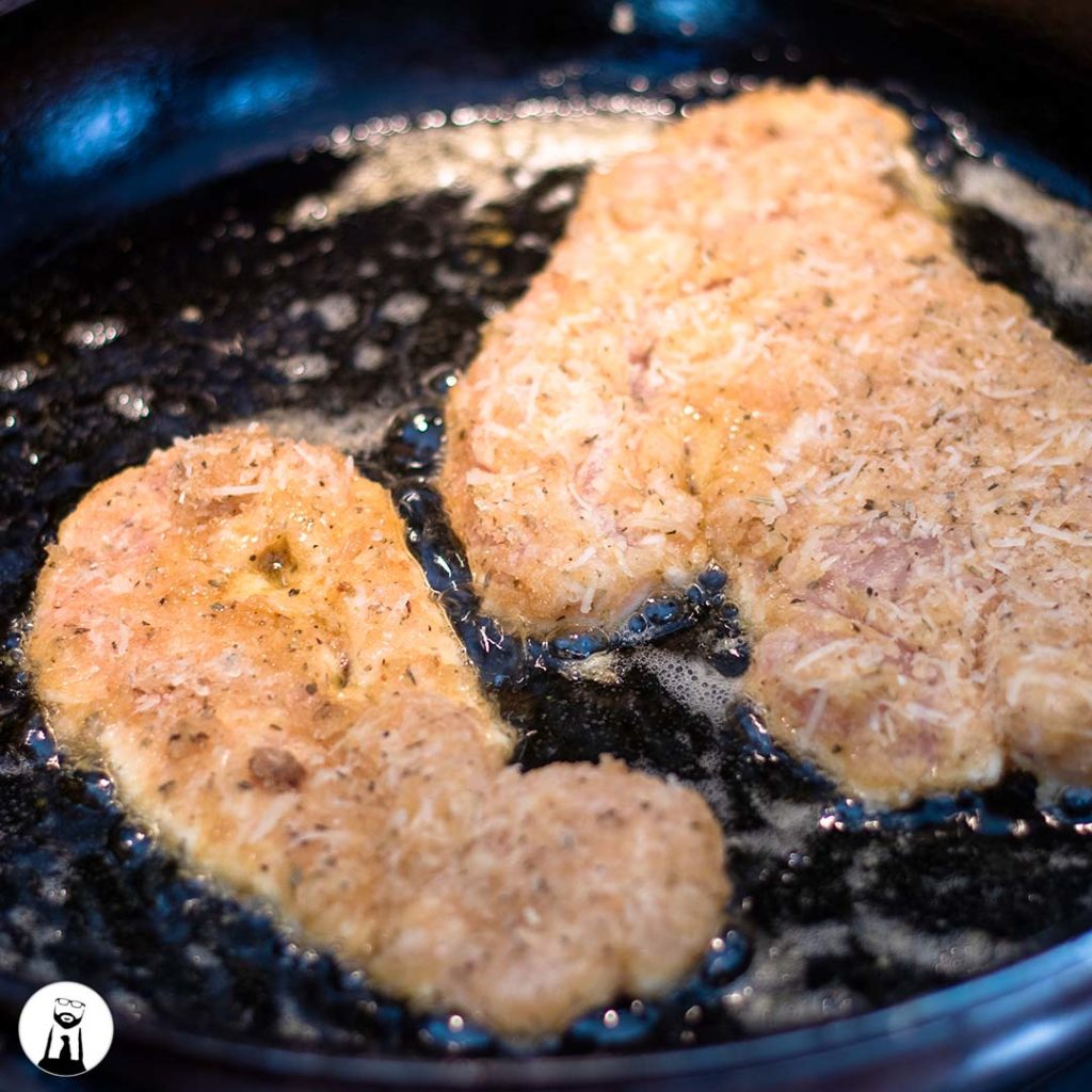 frying the breaded chicken in a skillet - Black Tie Kitchen